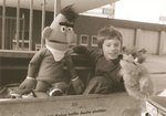 Der neunjährige Oskar-Fan Thomas Schwaiger erhält von Oberbrandinspektor Harald Selk eine Bert- und eine Oskar-Puppe. Quelle: Staatsarchiv Hamburg